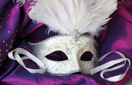 A mardi gras masquerade ball mask on a dress made from purple satinの写真素材