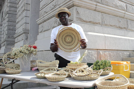 A Sweetgrass basket maker shows off his creations on Meeting street in Charleston, South Carolina, USA. A skill passed down from the African slaves, sweetgrass basket making is a dying art.Unique to the South Carolina Lowcountry, they are created from theのeditorial素材