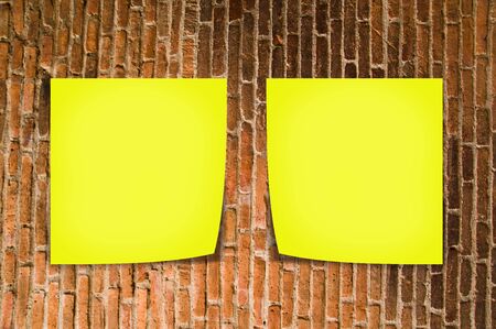 Yellow memo stick on old brick wall backgroundの写真素材