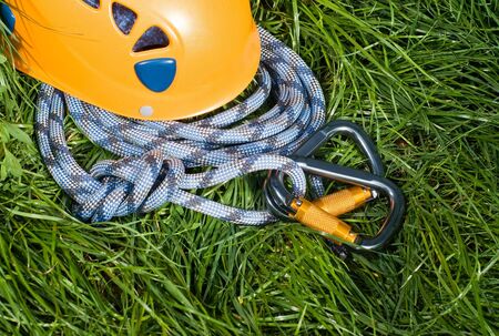 carabiners, helmet and rope on a green grassの写真素材