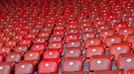 Rows of red chairs on the soccer stadiumの写真素材