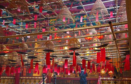 The interior of the Man Mo Temple, Hong Kong, with incense offerings and coils suspended from the ceiling.のeditorial素材