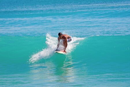 BALI, INDONESIA - JULY 27: Unidentified young man surfing the waves on July 27, 2010. Dreamland...