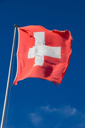 Swiss flag against blue skyの写真素材