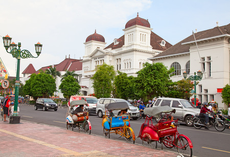 YOGYAKARTA - AUGUST 03: Traditional rikshaw transport on streets of Yogyakarta, Java, Indonesia on August 03, 2010. Bicycle rikshaw remains popular means of transport in many Indonesian cities.のeditorial素材