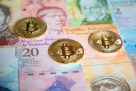 Bitcoins over the background made of Venezuela currencyの写真素材