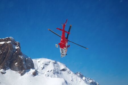 FLUMSERBERG - MARCH 25: The unidentified pilots of the swiss emergency service Rega performing training exercise in skiing area Flumserberg, Switzerland on March 25, 2018. のeditorial素材