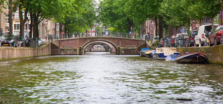 AMSTERDAM - JULY 10: Canals of the Amsterdam city on July 10, 2016 in Amsterdam, Netherlands. The historical canals of the city surrounded by traditional dutch houses is one of the main attractions of Amsterdam.のeditorial素材