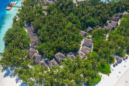 Small island in the Maldives covered by palms and surrounded by turquoise blue waters with with beautiful corals and animals, perfect escape from the cold winterのeditorial素材