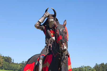 AGASUL, SWITZERLAND - AUGUST 18: Unidentified men in knight armor on the horse ready for action during tournament reconstruction near Kyburg castle on August 18, 2012 in Agasul, Canton Zurich, Switzerland.のeditorial素材