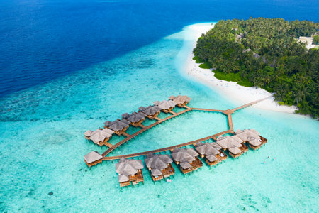 Small island in the Maldives covered by palms and surrounded by turquoise blue waters with with beautiful corals and animals, perfect escape from the cold winterの写真素材