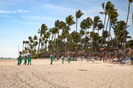 Unidentified people reamoving Sargassum seaweeds on Bavaro Beach near Punta Cana, Dominican Republic