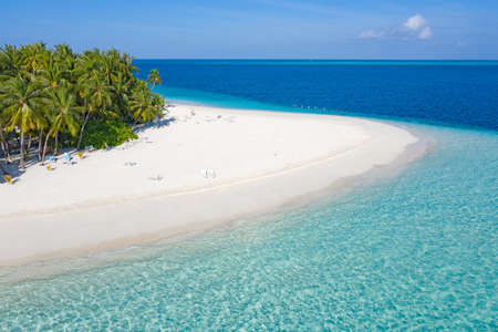 Small island in the Maldives covered by palms and surrounded by turquoise blue waters with with beautiful corals and animals, perfect escape from the cold winterの写真素材