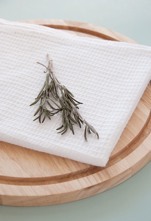 Rosemary on the white towel and round breadboardの写真素材