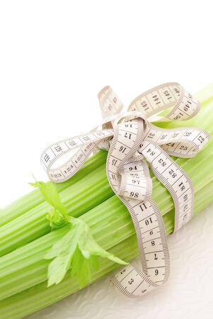 Celery with tape measure on the white background, concept of healthy nutrition and dietの写真素材