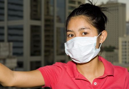 asian woman with face mask in front of the bangkok skylineの写真素材