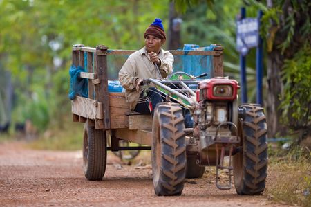 farmer on his small tractor on the countryside in thailandの写真素材
