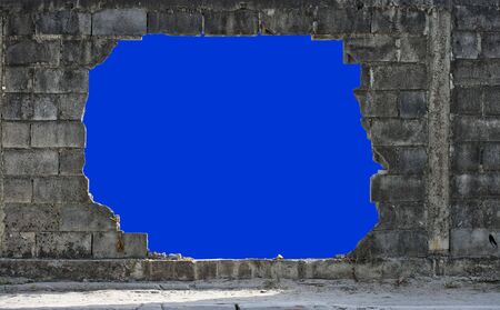 hole in a brickwall, isolated on blueの写真素材