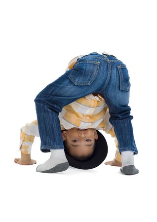 cute boy looking through his own legs, isolated on white backgroundの写真素材