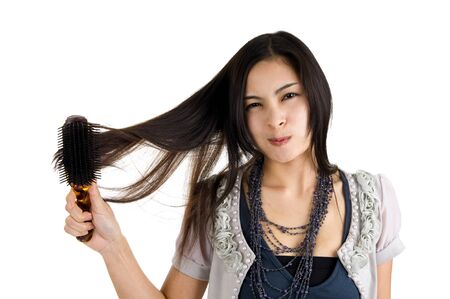 pretty woman brushing her long hair, isolated on white backgroundの写真素材