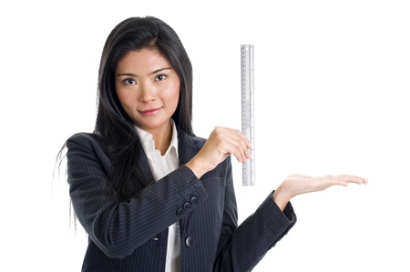 business woman holding a ruler to show the size of something, isolated on white backgroundの写真素材