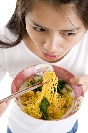 asian woman eating with chop sticks, isolated on whiteの写真素材