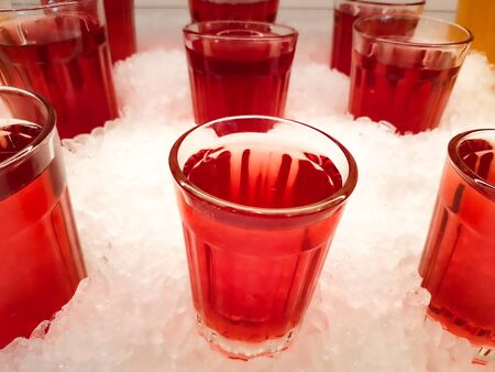 Several glasses of red juice put on iceの写真素材
