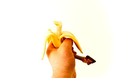 man's hand holding a peeled banana with a bite with white backgroundの写真素材