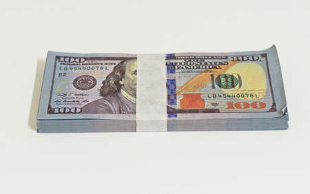 wad of 100 dollar bills in a white background placed horizontally