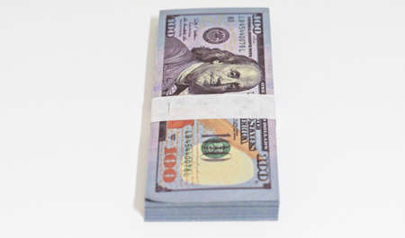 wad of 100 dollar bills in a white background placed verticallyの写真素材