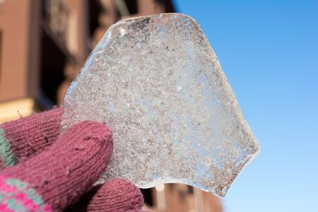 a piece of ice on a background of blue sky, unusually shaped piece of iceの写真素材