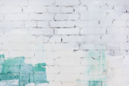 The brick wall is painted with green and white paint. Background with space for text, texture.の写真素材