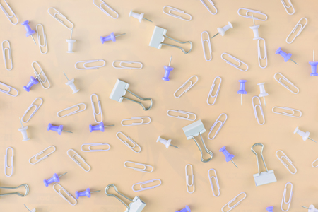 Bright yellow background. Stationery chaotically scattered. Staples and buttons are in disarray.の写真素材