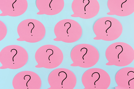 Sticky notes on a blue background. Pink stickers with question marks. A vivid unusual photo.の写真素材