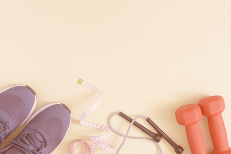 Fitness background with space for text. Toned photo. Sneakers, dumbbells, skipping rope and tape measure. Mock up.の写真素材