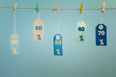 Labels hang on a rope attached with clothespins. The values of the discount are written on them,...