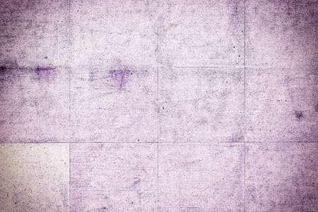 Wall of large stone tiles of lilac color. The texture of the stone with cracks and scratches.の写真素材