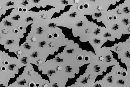 On the gray surface are lined with many decorative bats, asterisks and puppet eyes. Halloween background.の写真素材