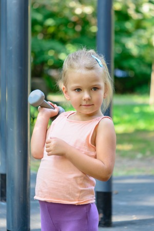Little girl with blond hair on the sports field.