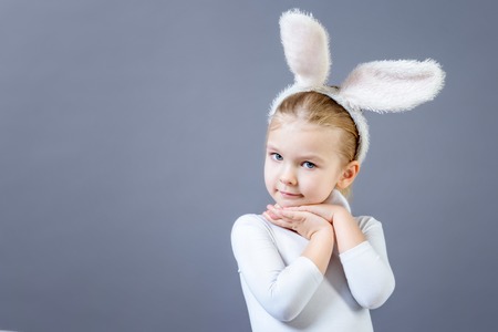Baby in a white rabbit costume on a grayの写真素材
