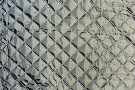 Texture, dark gray quilted fabric close up. Blank background.の写真素材