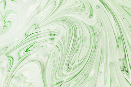 The process of mixing white and light green paint close-up. Abstract background for layouts.の写真素材