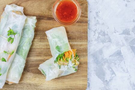 On a light  cutting board with spring roll