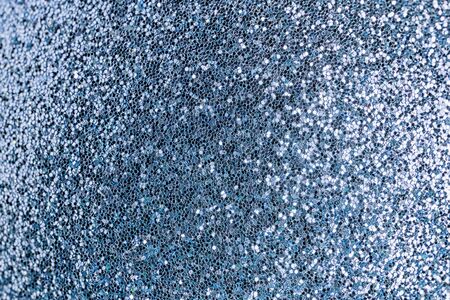 Bright shiny blue background for sites and layouts. The surface of many small sparkles, closeup. Selective focus.の写真素材
