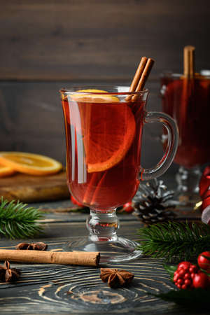 Glass with Christmas mulled wine, orange and cinnamon. Holiday atmosphere. Close-up photo.の写真素材