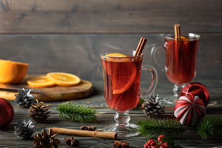 A holiday photo with two glasses of mulled wine with orange and cinnamon. Cozy Christmas atmosphere.の写真素材