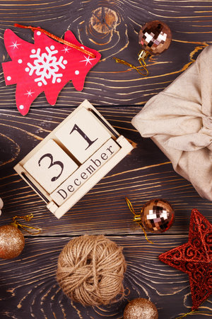 Calendar with date of December 31. Around New Year and Christmas decorations. Gifts wrapped in cloth.の写真素材