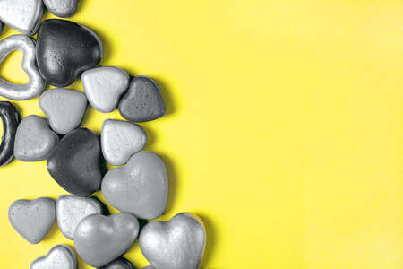Gray hearts on a yellow background, trending colors of 2021. Copy space, modern Valentines Day concept.の写真素材
