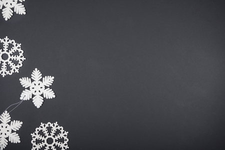 White Christmas tree toys in the form of snowflakes lie on a black background. Christmas card mockupの写真素材