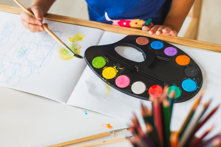 3 years girl painting at the small table at home. Home schooling conceptの写真素材